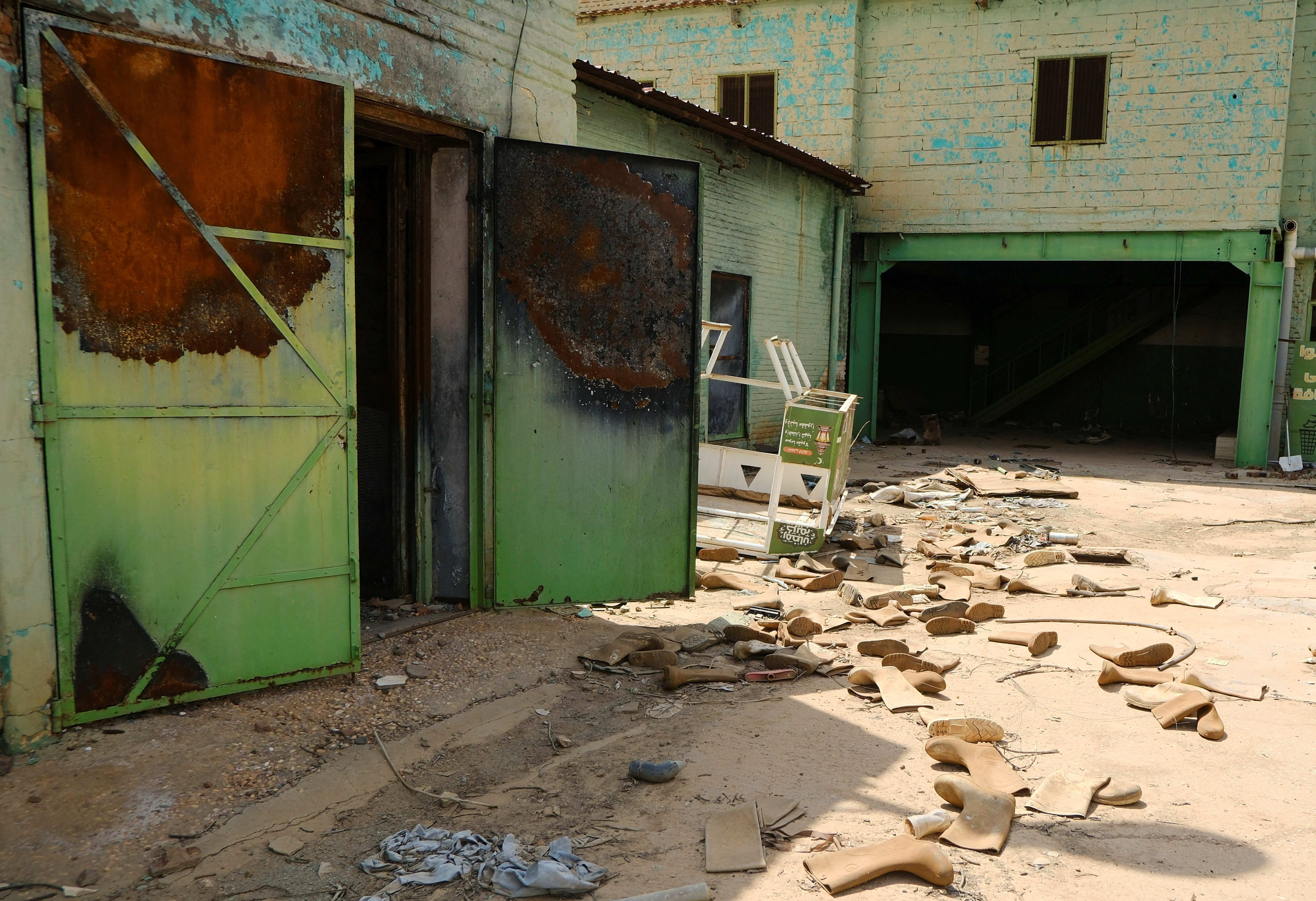 Safety shoes are scattered in a destroyed factory in Omdurman