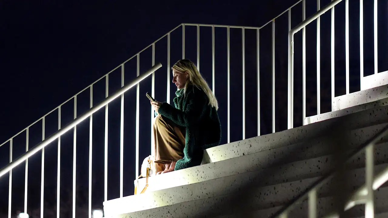 A woman uses her smartphone as the Albanian government lifts a ban on TikTok after nearly a year