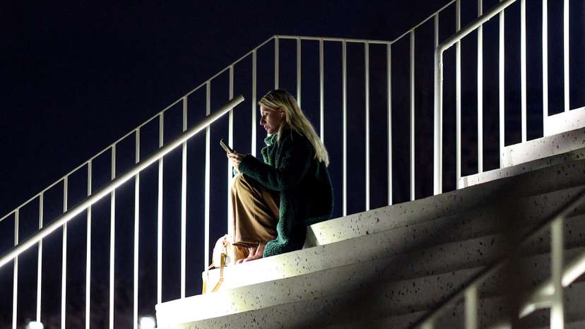 A woman uses her smartphone as the Albanian government lifts a ban on TikTok after nearly a year