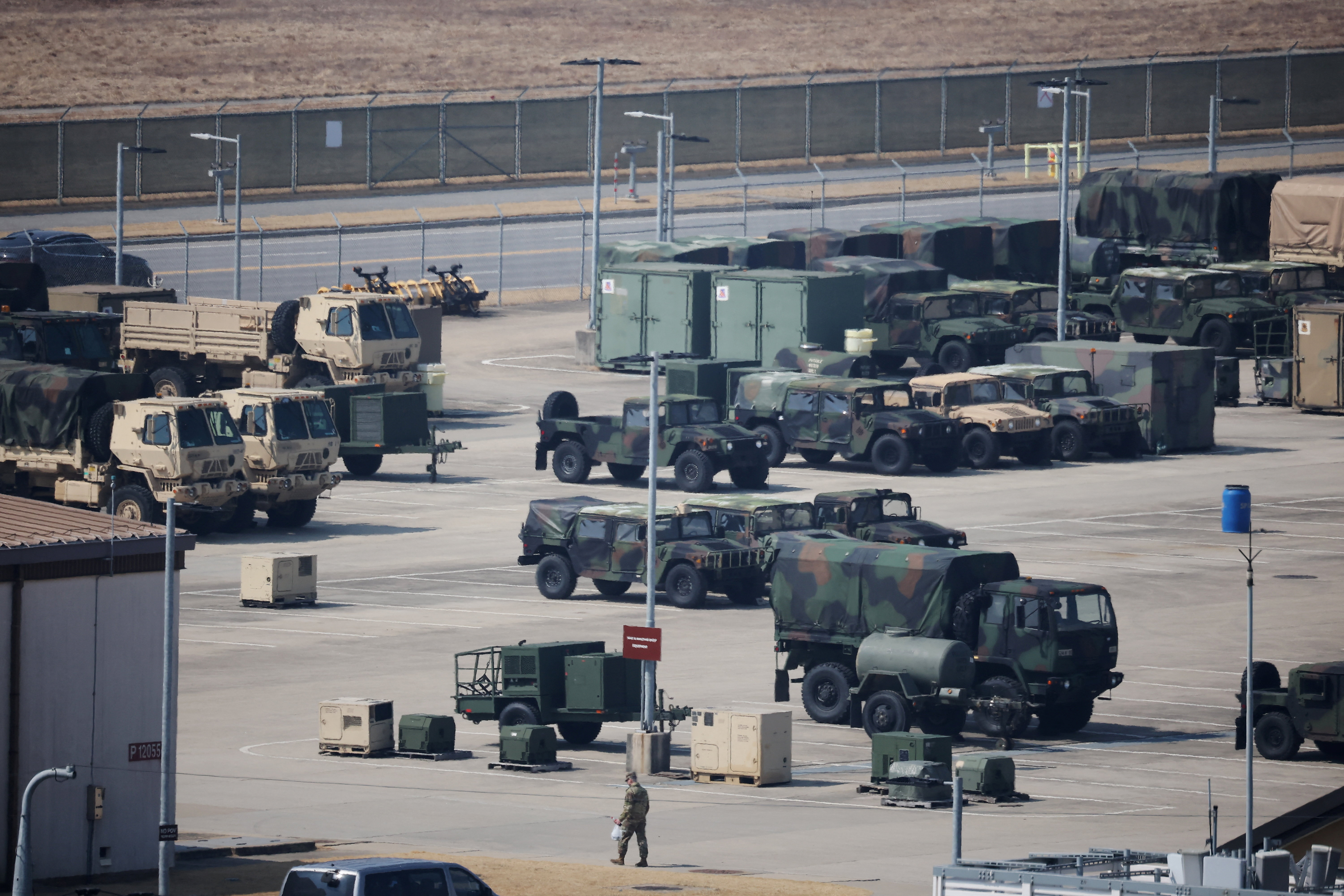 A U.S. army soldier walks past military vehicles at a U.S army base in Pyeongtaek