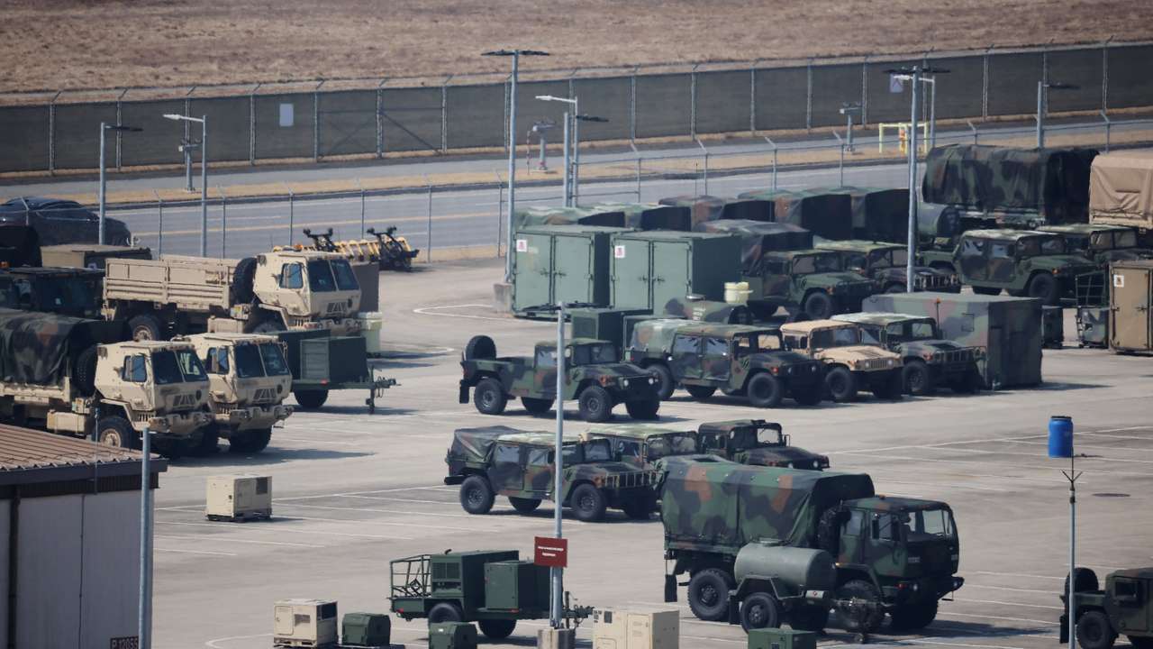 A U.S. army soldier walks past military vehicles at a U.S army base in Pyeongtaek