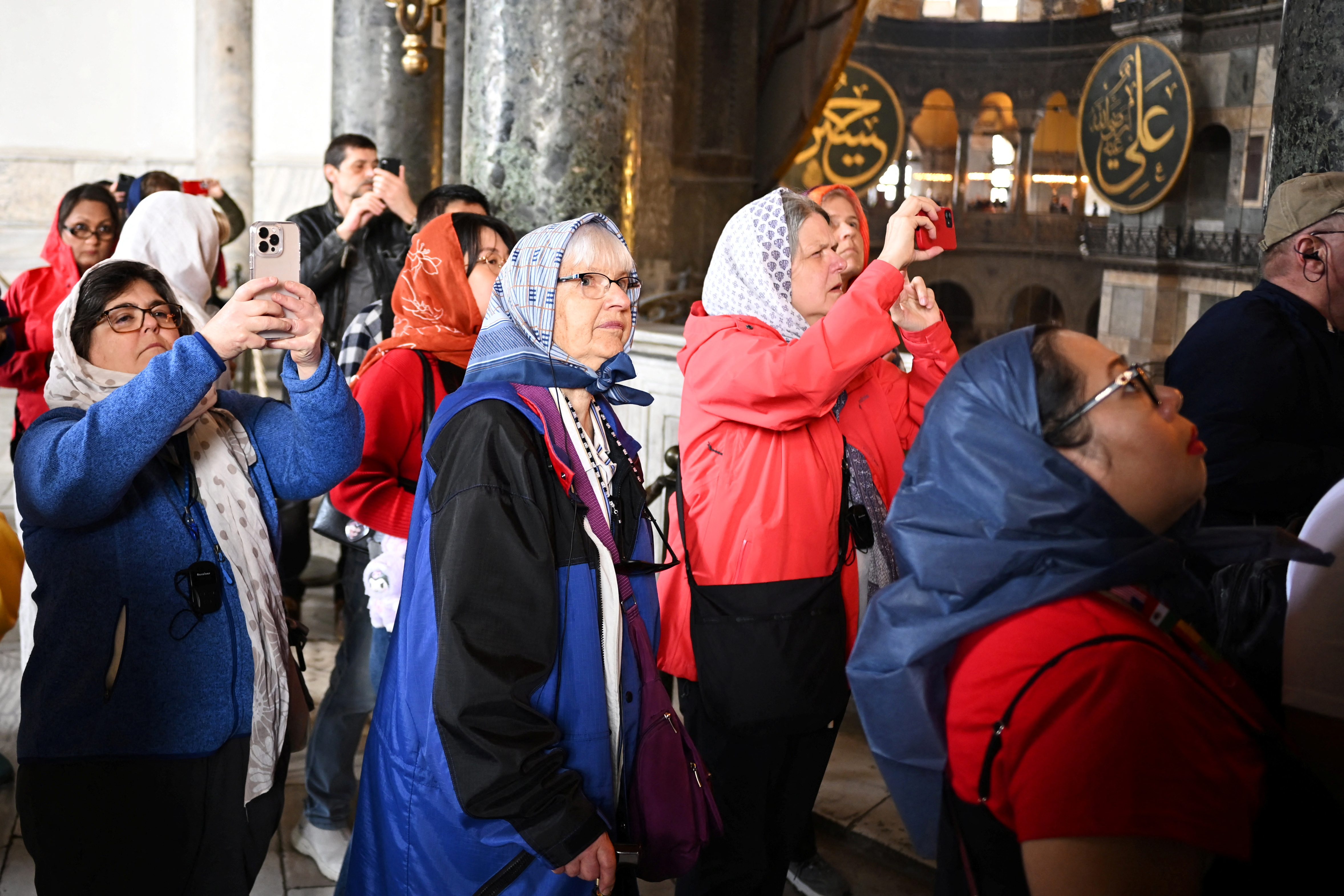 People take photos as they tour the Hagia Sophia Grand Mosque, during Eid al-Fitr, in Istanbul
