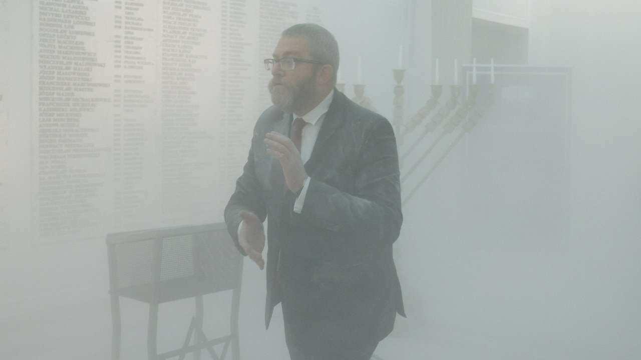 Far-right Polish lawmaker Grzegorz Braun from Konfederacja walks after using a fire extinguisher to put out Hanukkah candles at the parliament in Warsaw