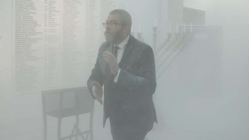 Far-right Polish lawmaker Grzegorz Braun from Konfederacja walks after using a fire extinguisher to put out Hanukkah candles at the parliament in Warsaw