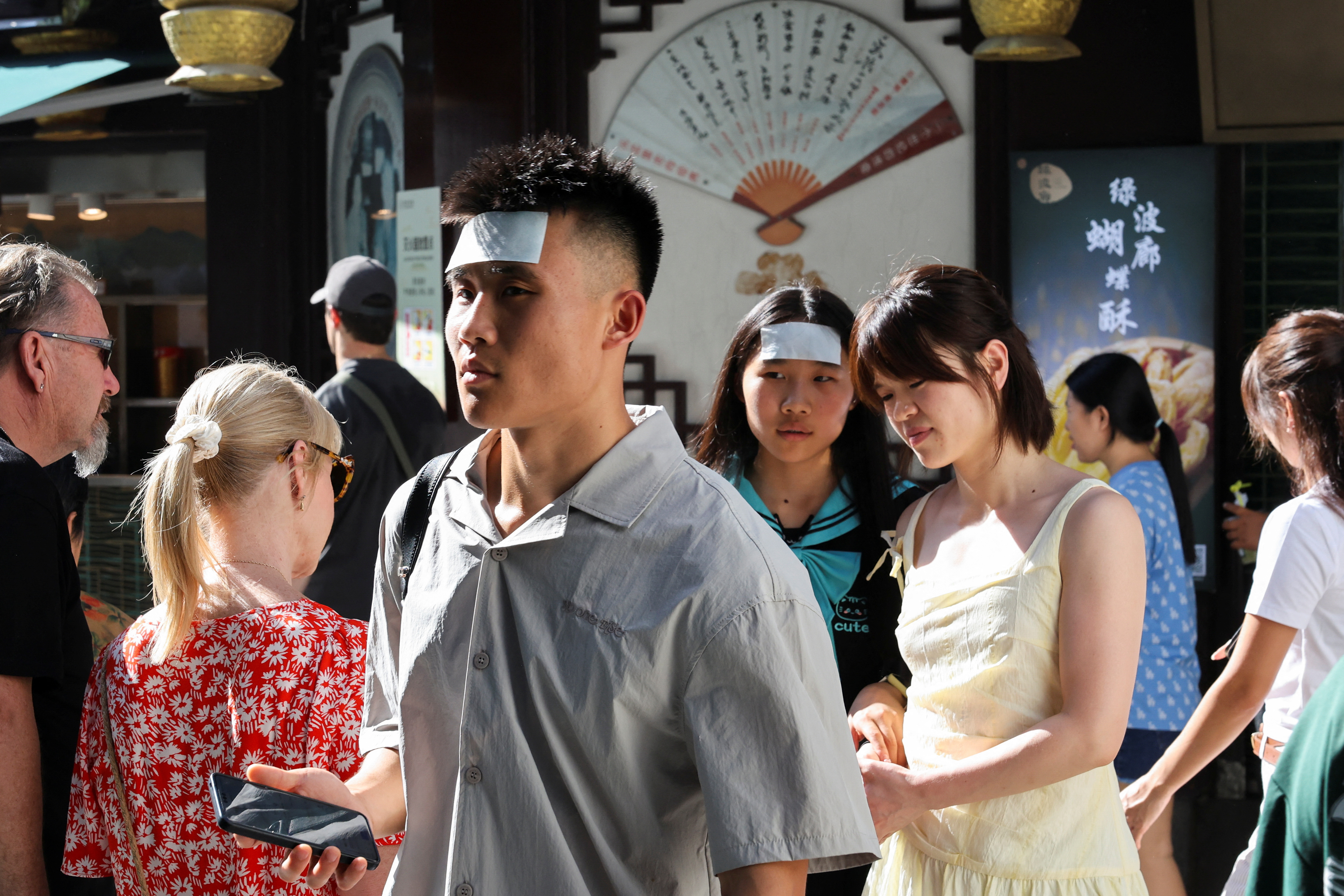 People put cooling gel sheets on their foreheads to cool themselves amid a yellow alert for heat, in Shanghai