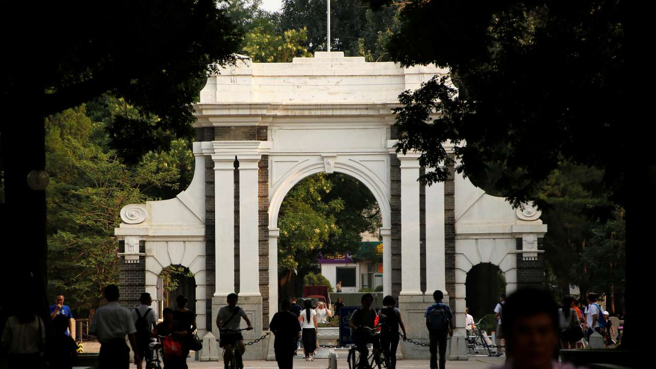 People walk near the gate of Tsinghua University in Beijing