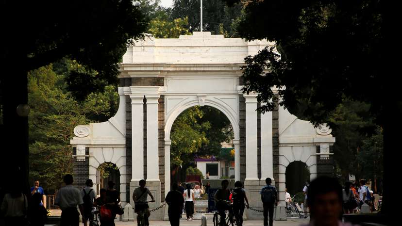 People walk near the gate of Tsinghua University in Beijing