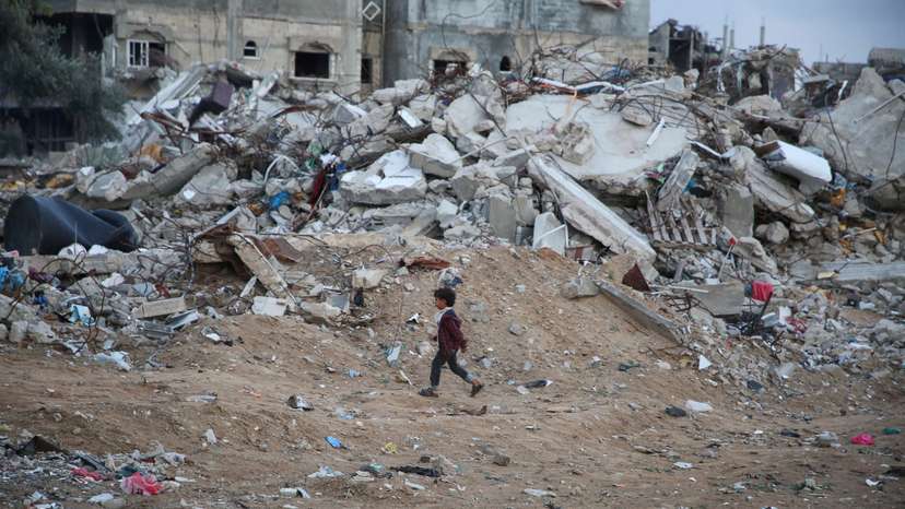 A Palestinian child walks past the rubble of a building destroyed during the Israeli offensive, amid a ceasefire between Israel and Hamas, in Rafah