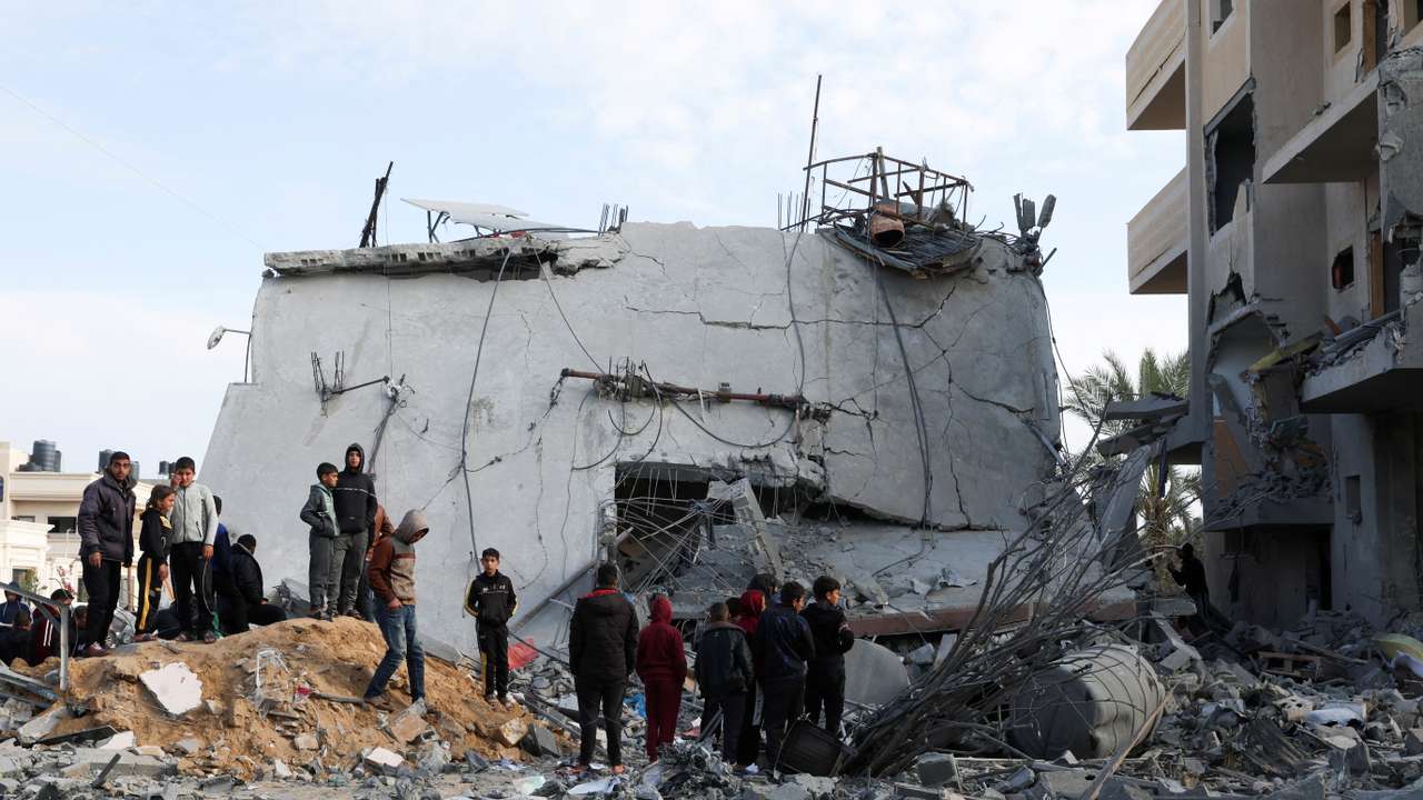 FILE PHOTO: Palestinians gather near a house hit by an Israeli strike, in Rafah in the southern Gaza Strip