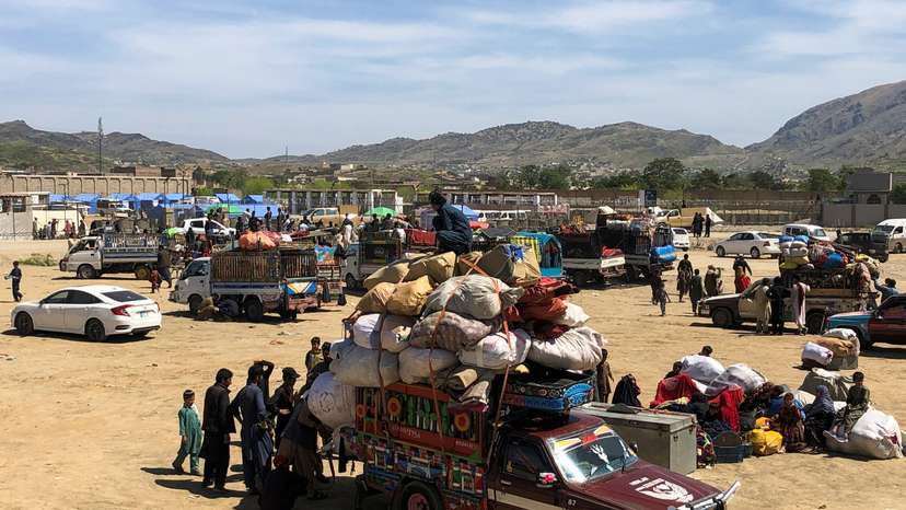 Afghan nationals with their belongings gather as they head back to Afghanistan, at the Torkham border crossing