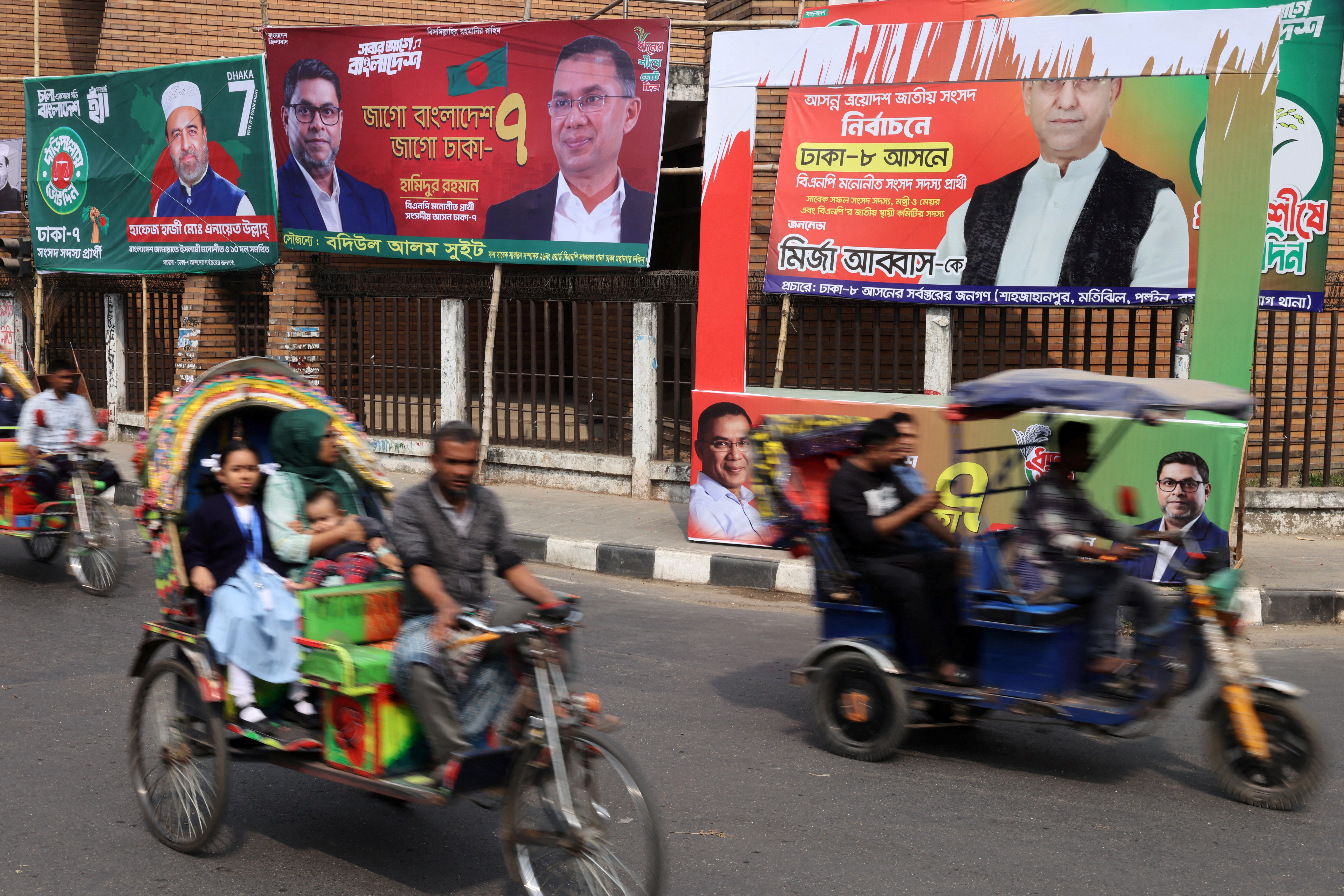 FILE PHOTO: Vehicles pass by election campaign banners ahead of the national election, in Dhaka