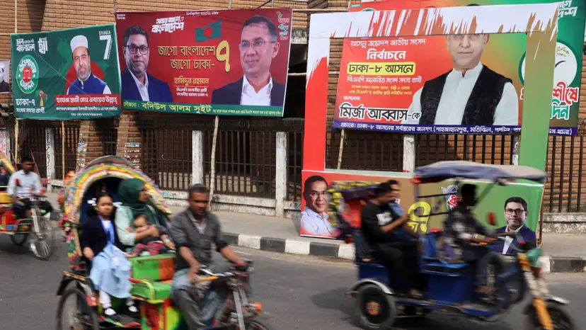 FILE PHOTO: Vehicles pass by election campaign banners ahead of the national election, in Dhaka