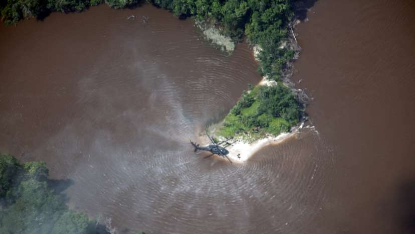 A Colombian Air Force helicopter flies over an illegal mining site for gold extraction during a joint operation between Colombian and Brazilian authorities in the Amazon jungles