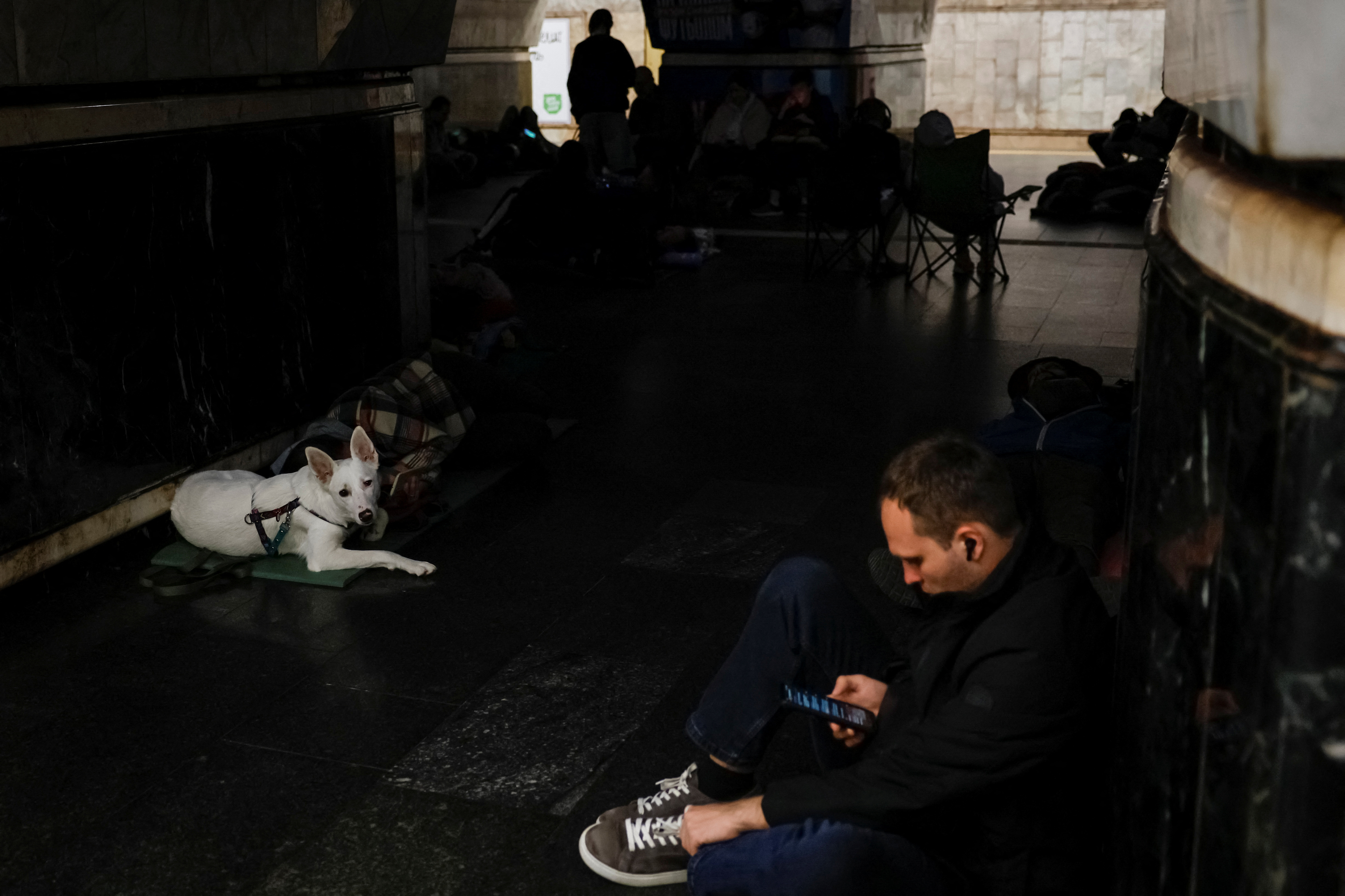 People take shelter inside a metro station during a Russian military attack, in Kyiv