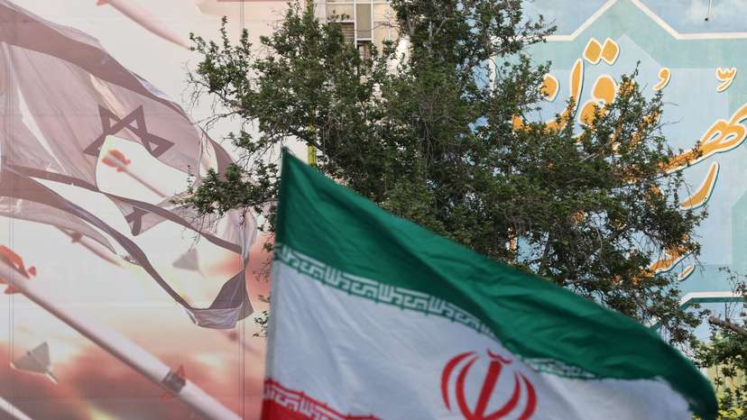 FILE PHOTO: An anti-Israel billboard is seen next to the Iranian flag during a celebration following the IRGC attack on Israel, in Tehran
