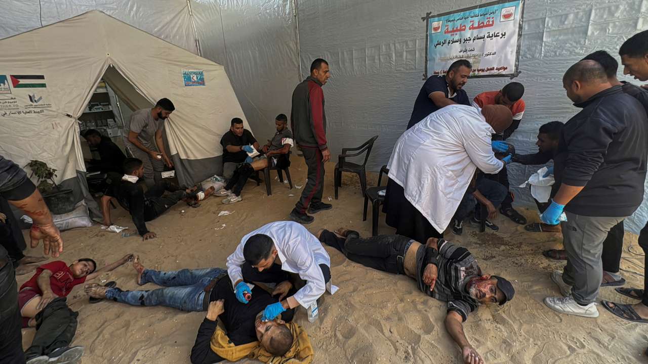 Palestinians assist casualties following an Israeli strike, in Beit Lahiya