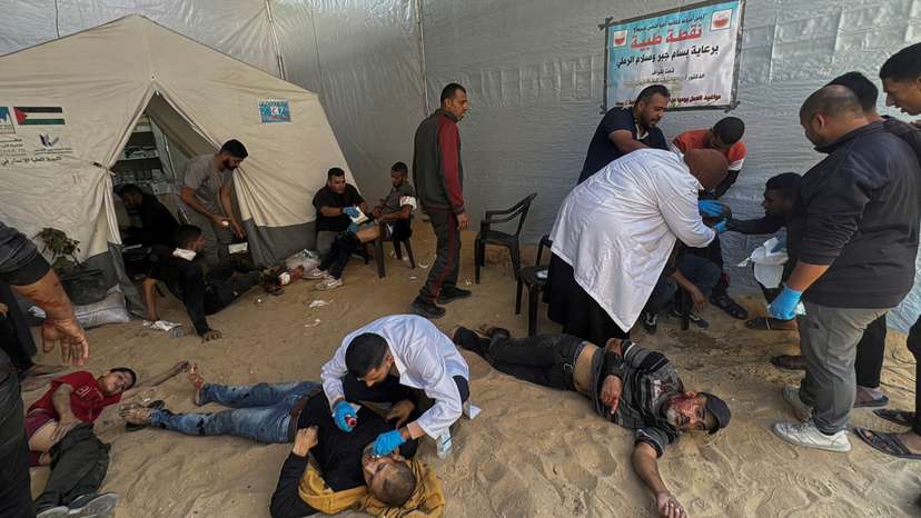 Palestinians assist casualties following an Israeli strike, in Beit Lahiya