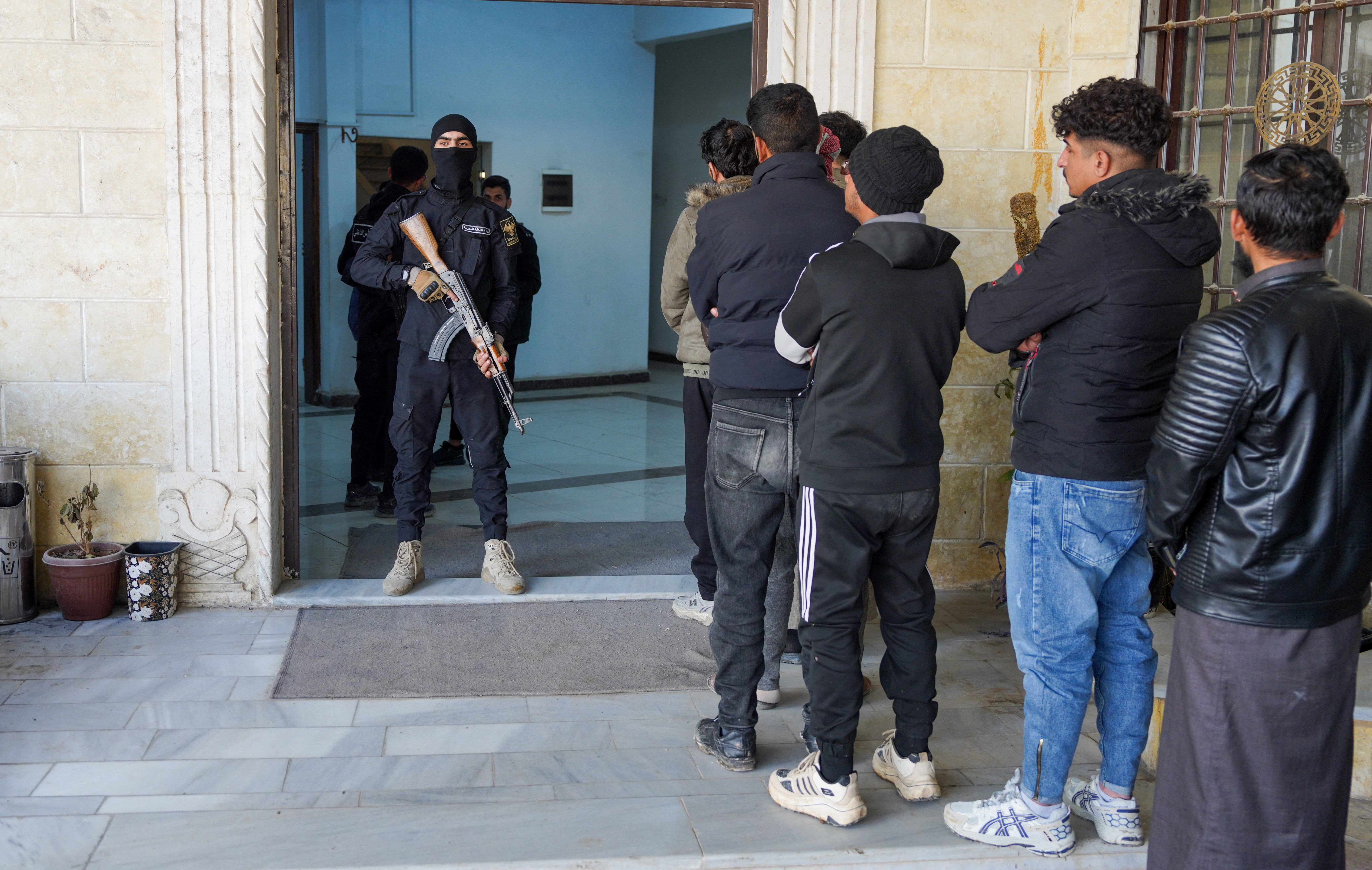 Members of the Kurdish-led Syrian Democratic Forces (SDF) queue to settle their status with Syrian government in Raqqa