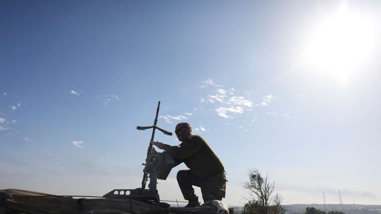 An Israeli soldier adjusts a weapon on top of a vehicle, amid the ongoing conflict between Israel and the Palestinian Islamist group Hamas, near Israel's border with Gaza