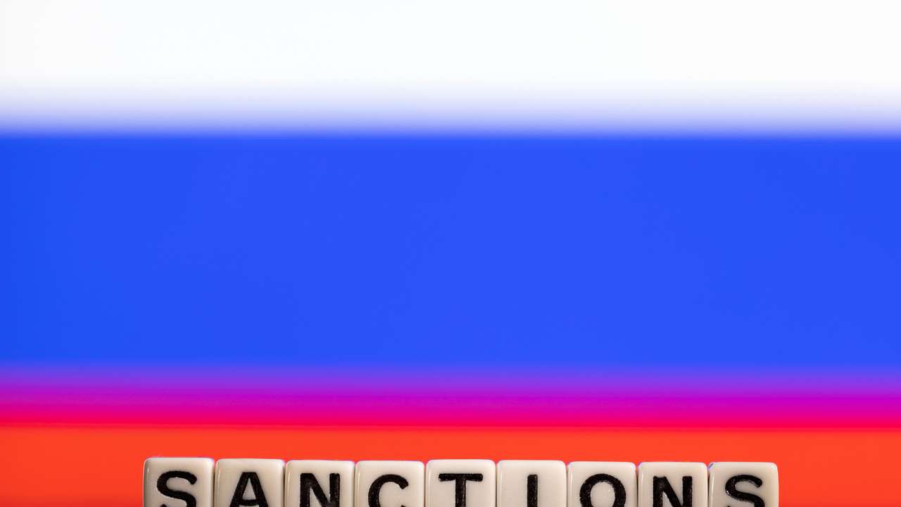 Illustration shows letters arranged to read "Sanctions" in front of Russian flag colors