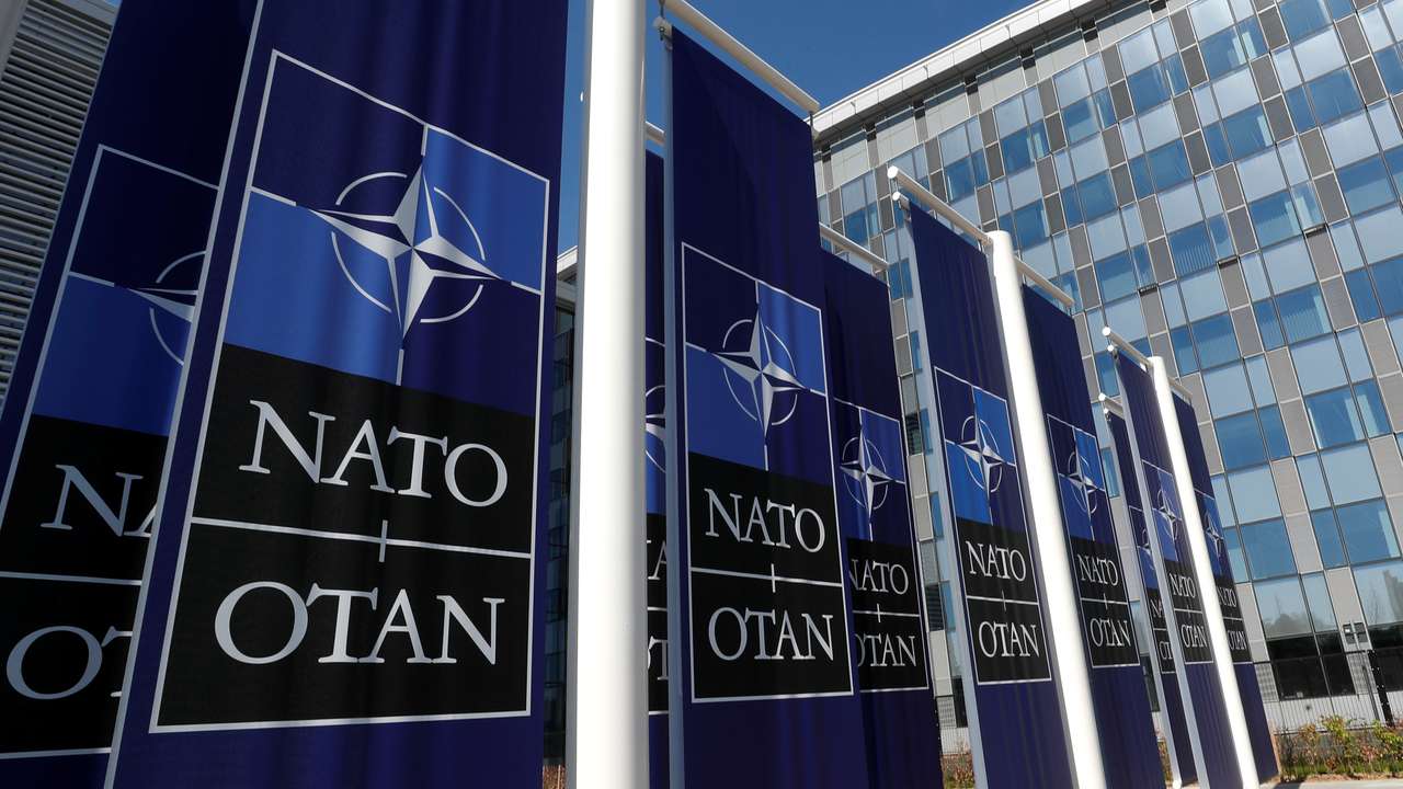 Banners displaying the NATO logo are placed at the entrance of new NATO headquarters during the move to the new building