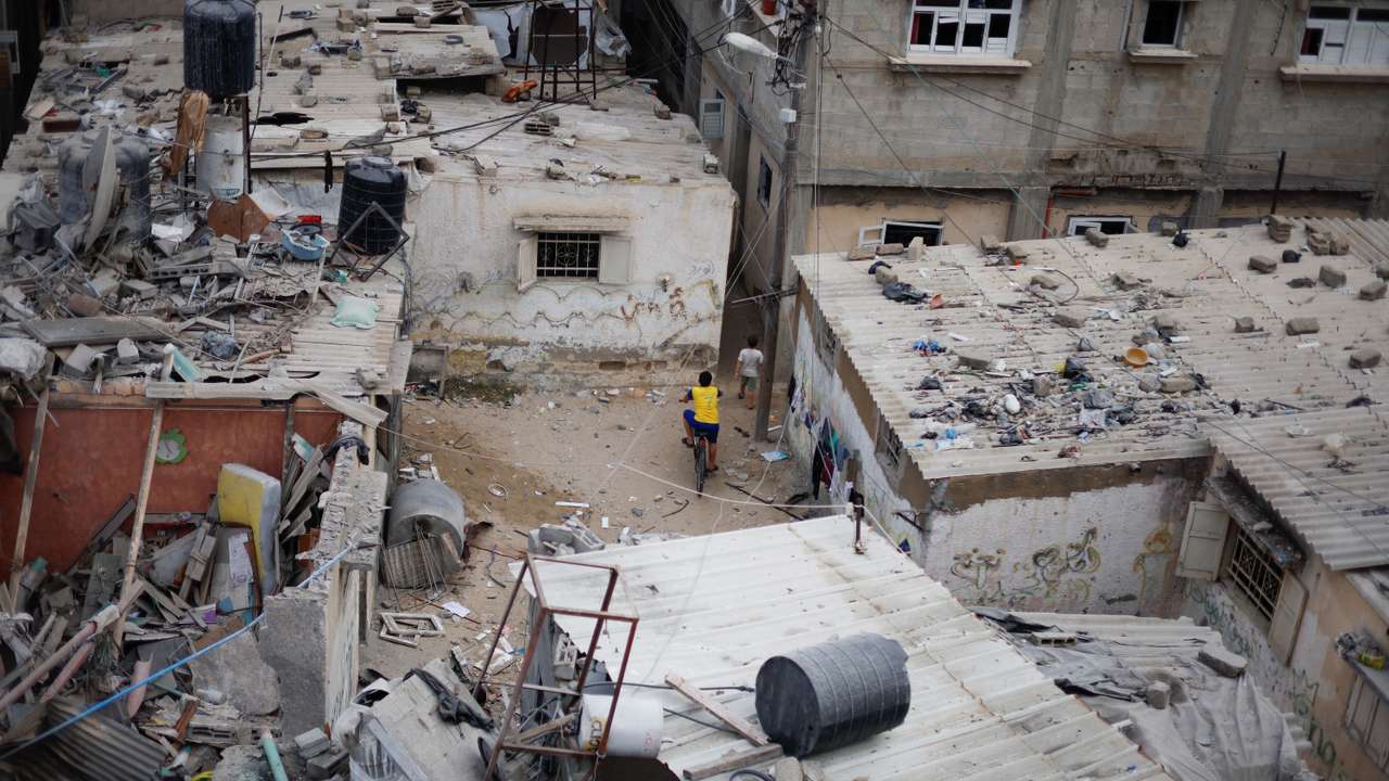 Emergency personnel and people check the damage at the site of Israeli strikes on houses in Khan Younis