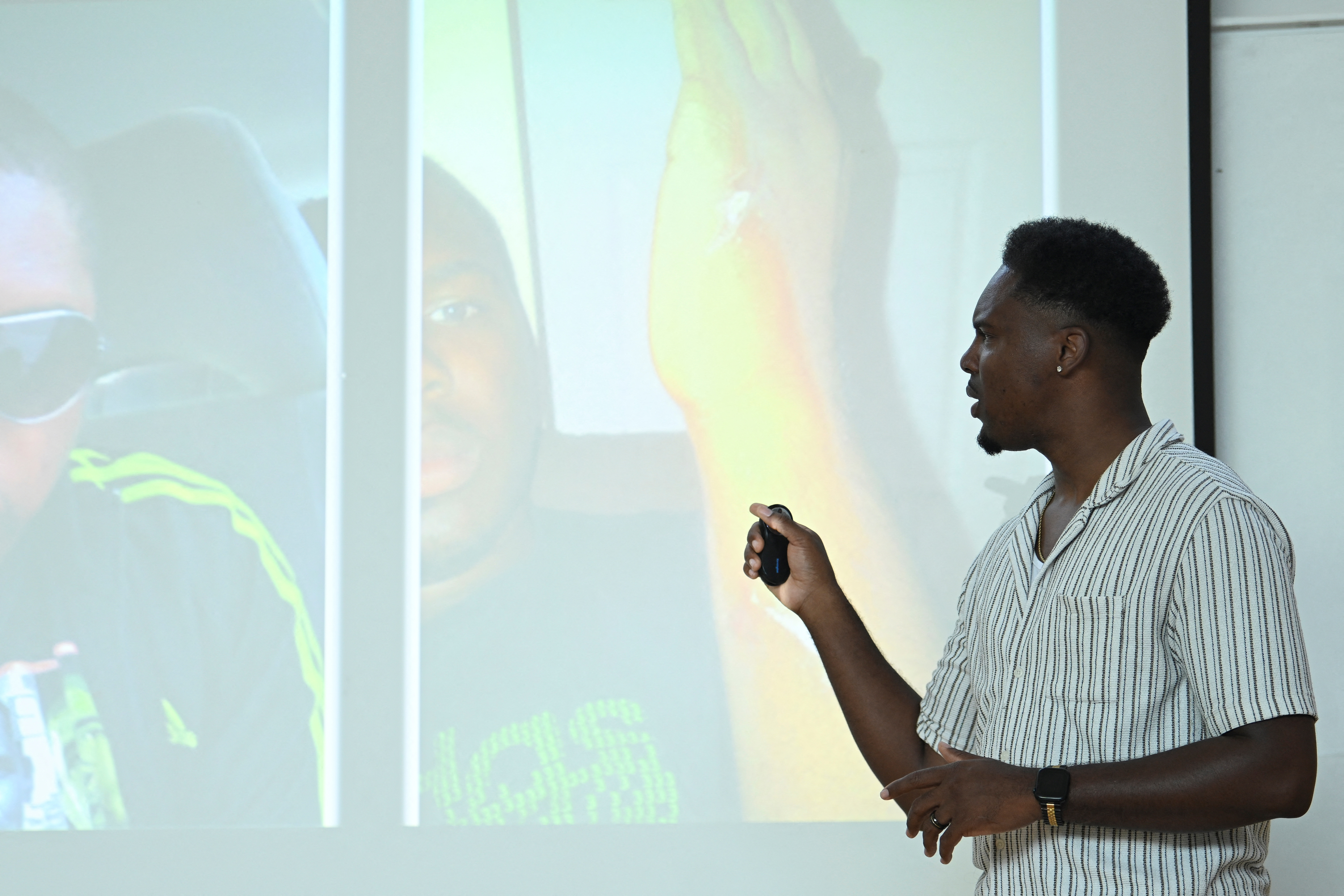 Amani Simpson, knife attack survivor, youth coach and filmmaker presents to school children in London