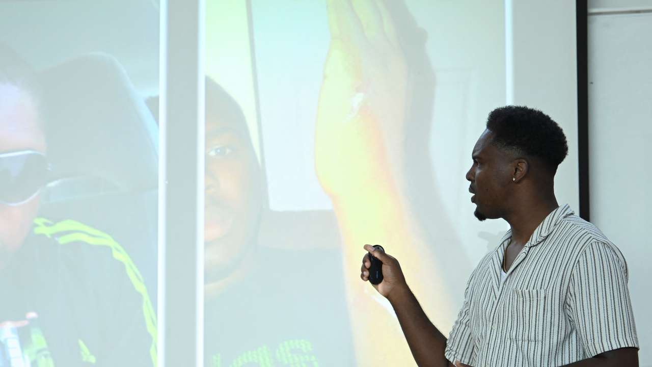 Amani Simpson, knife attack survivor, youth coach and filmmaker presents to school children in London