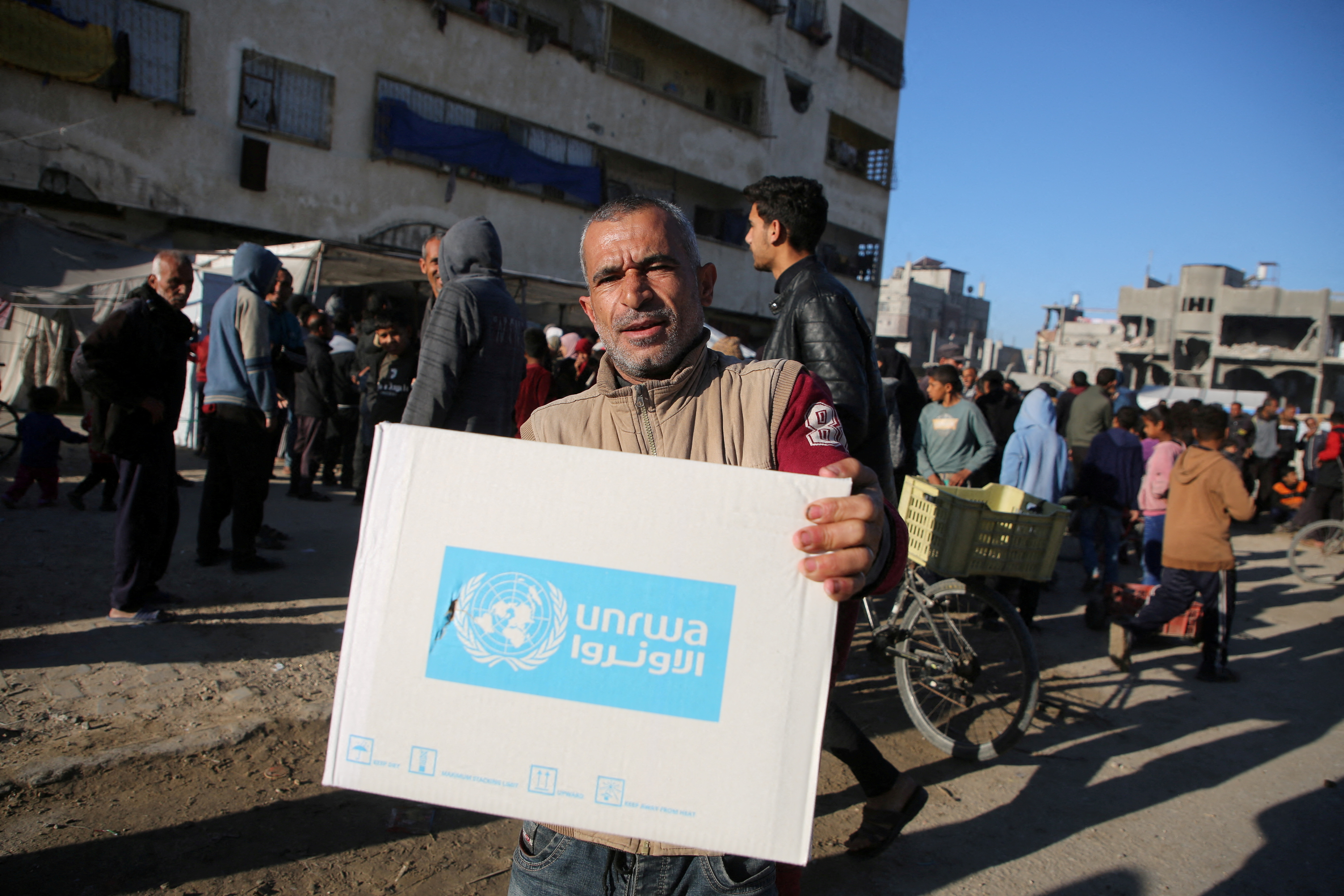 FILE PHOTO: Palestinians receive aid following a ceasefire between Israel and Hamas, in Khan Younis in the southern Gaza Strip