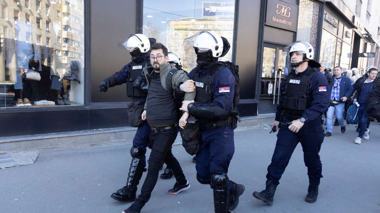 Police officers detain people during a protest in Belgrade