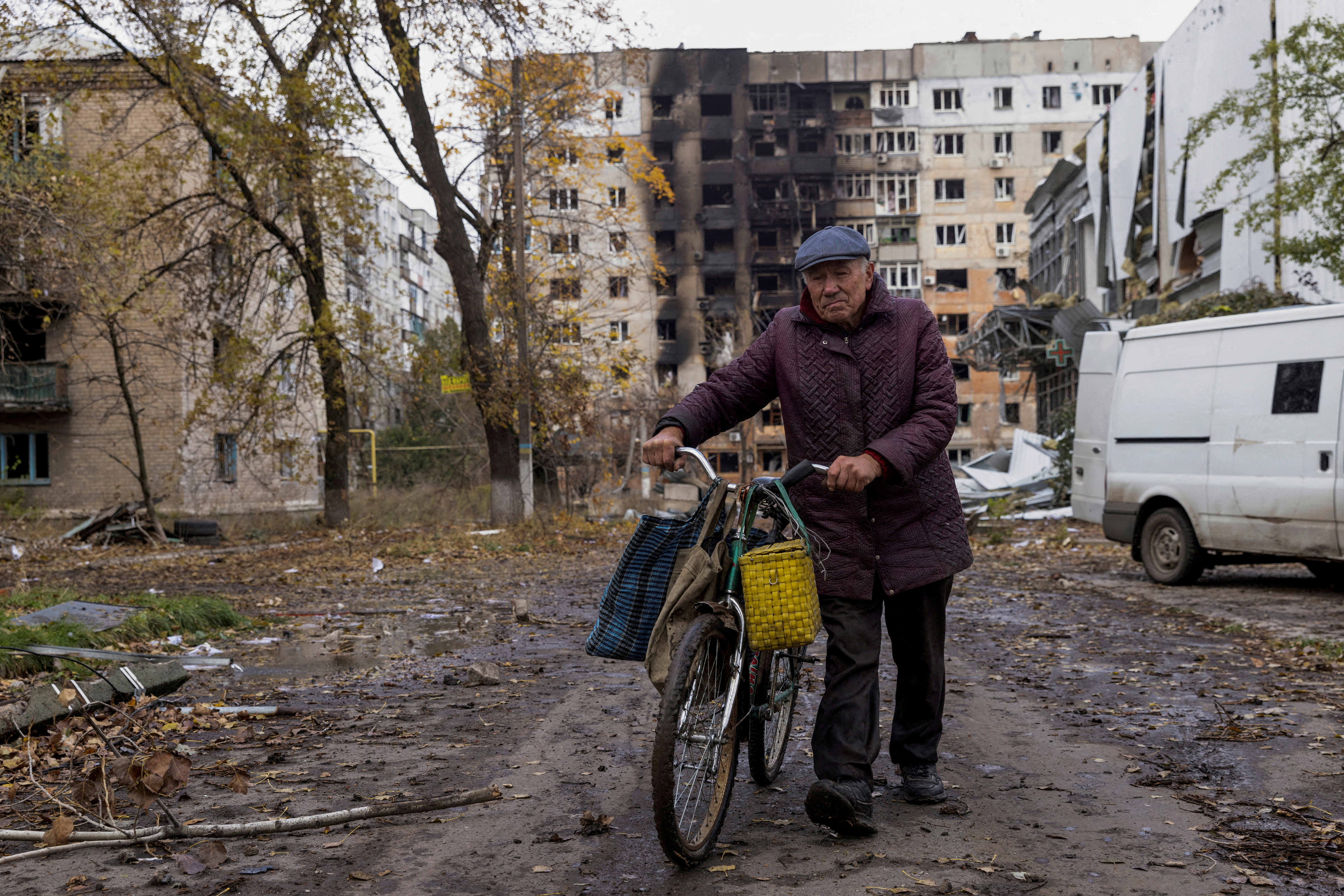FILE PHOTO: Local resident walks in front of damaged residential buildings in Avdiivka