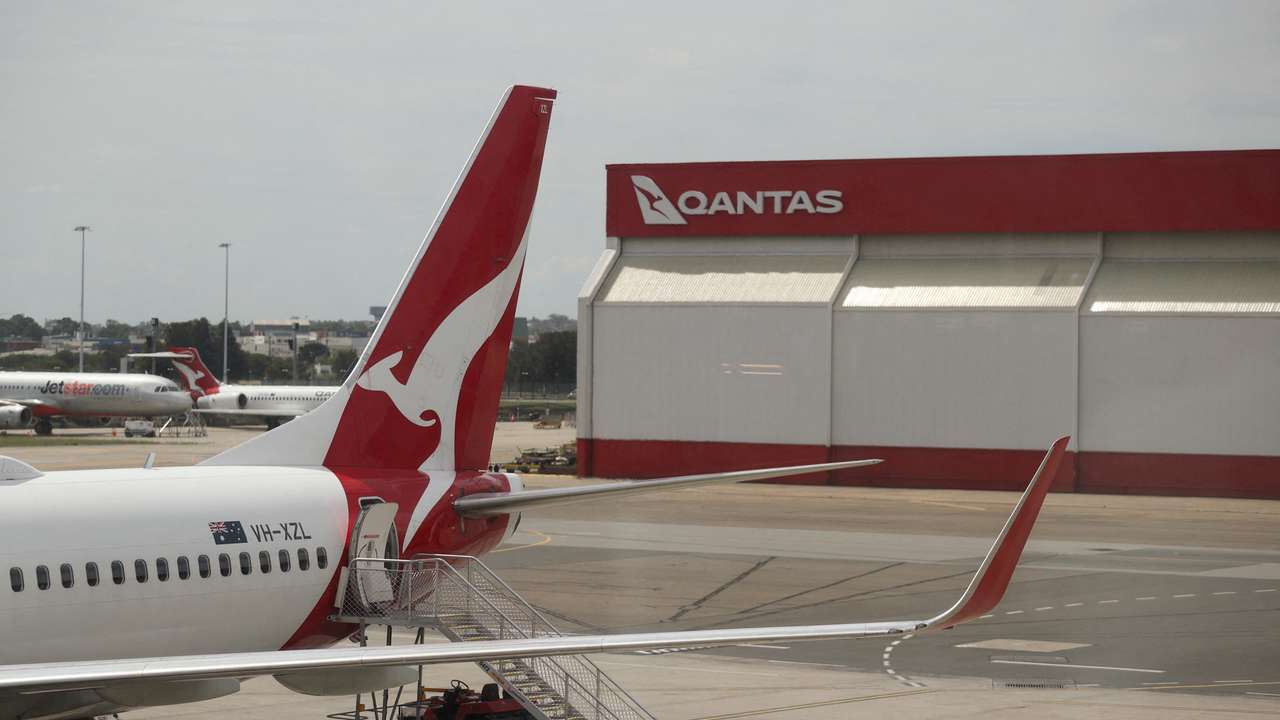 FILE PHOTO: A crew member walks from a Qantas plane at a domestic terminal at Sydney Airport in Sydney