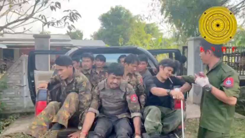 Myanmar military soldiers who have surrendered to the Karenni Nationalities Defense Force ride in the back of a vehicle in Loikaw