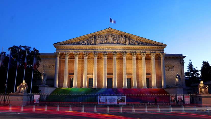 A French flag flutters on top of the National Assembly in Paris