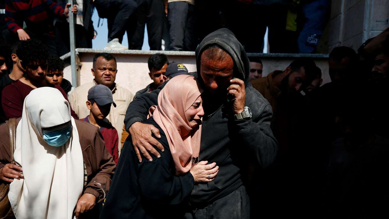 Mourners react next to the bodies of Palestinians killed in an Israeli strike