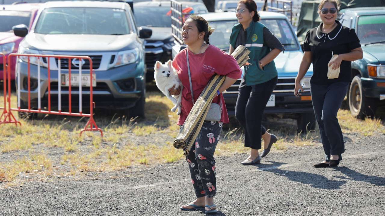 People rest at a shelter, following fresh military clashes between Thailand and Cambodia along parts of their disputed border, in Buriram province