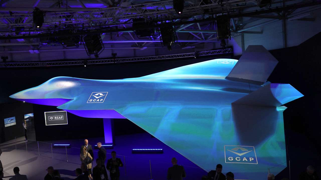 Attendees view GCAP concept fighter plane at the BAE Systems pavilion at Farnborough International Airshow, in Farnborough