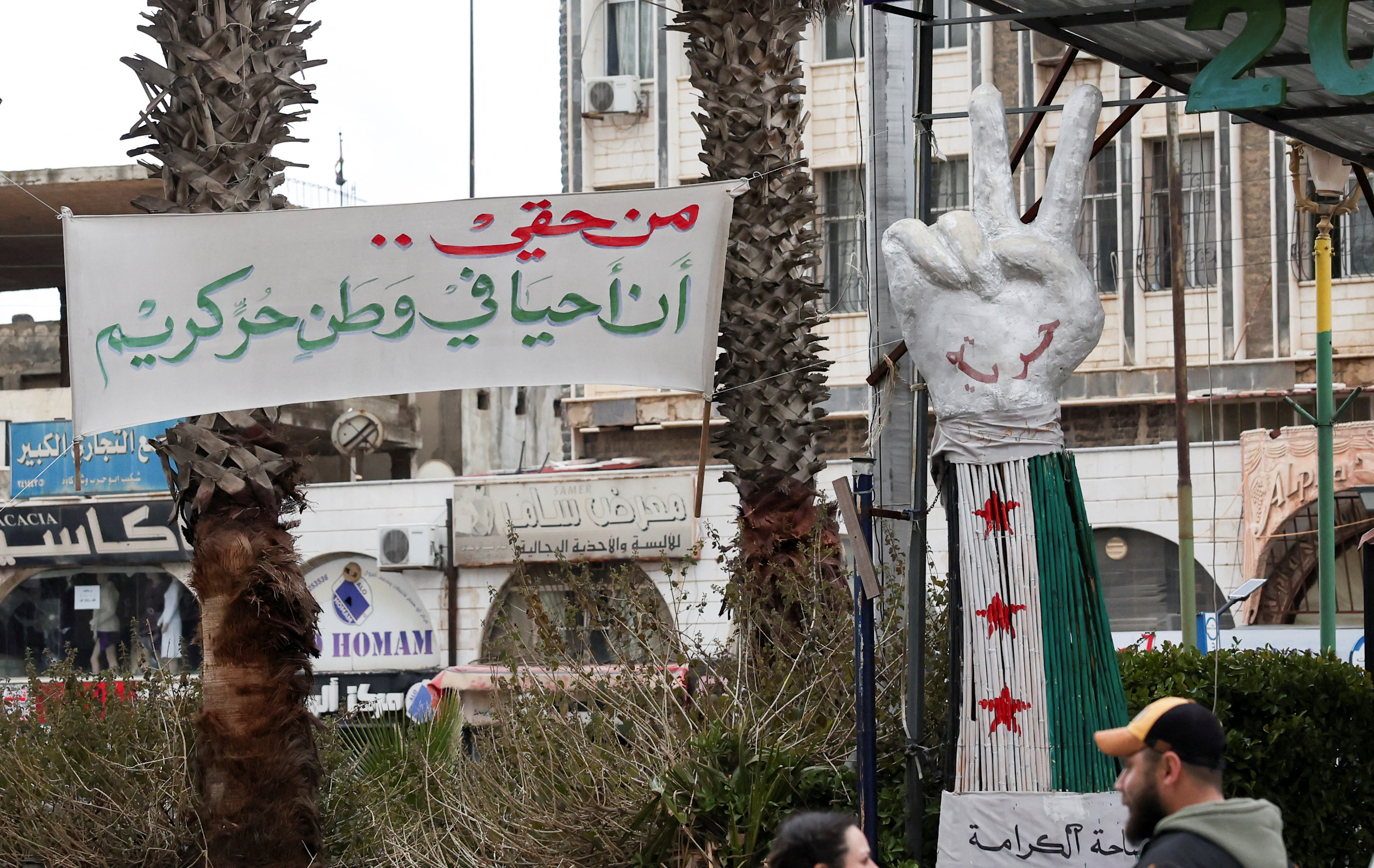 A banner reading "I have the right to live in a free and dignified homeland" is put up at Al-Karama Square in Sweida