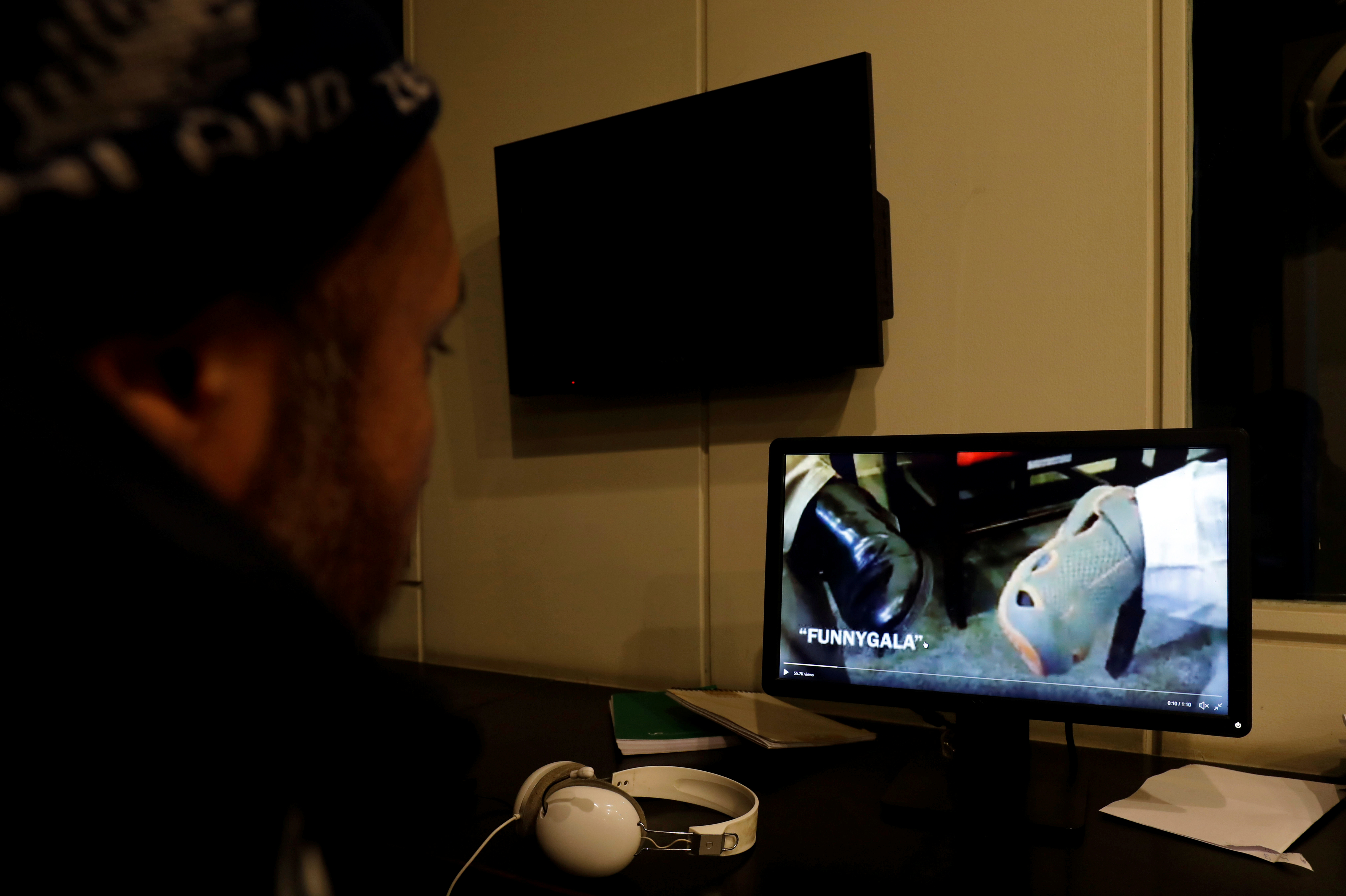 FILE PHOTO: A man looks at a computer screen displaying, what they say is a satire video clip on a social media site, in Islamabad