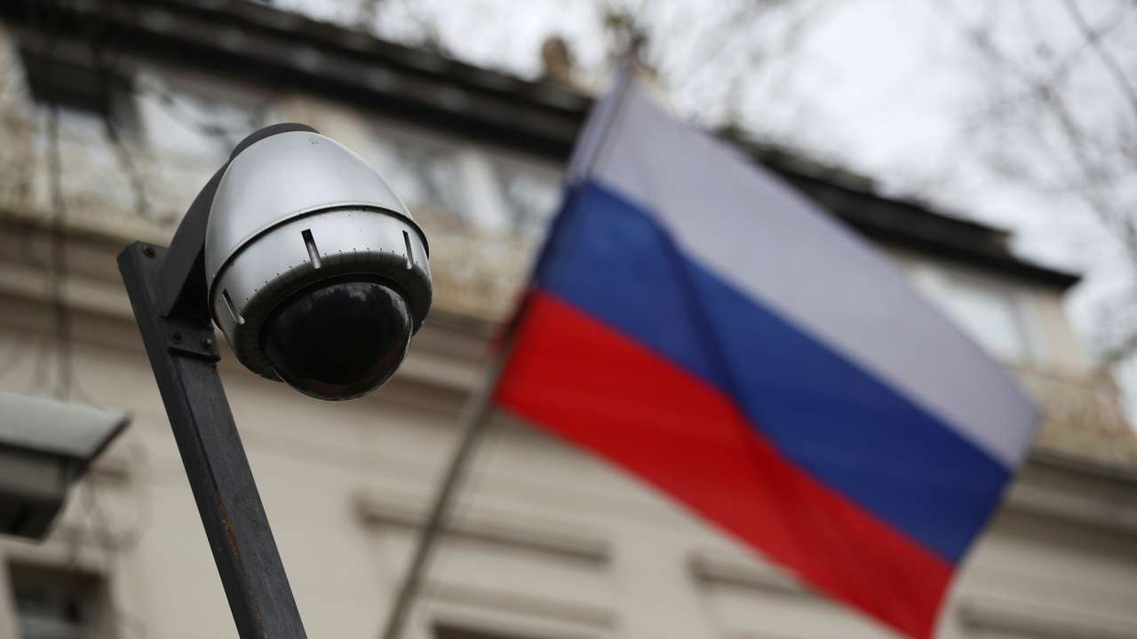 A security camera is seen, and a flag flies outside the consular section of Russia's embassy in London