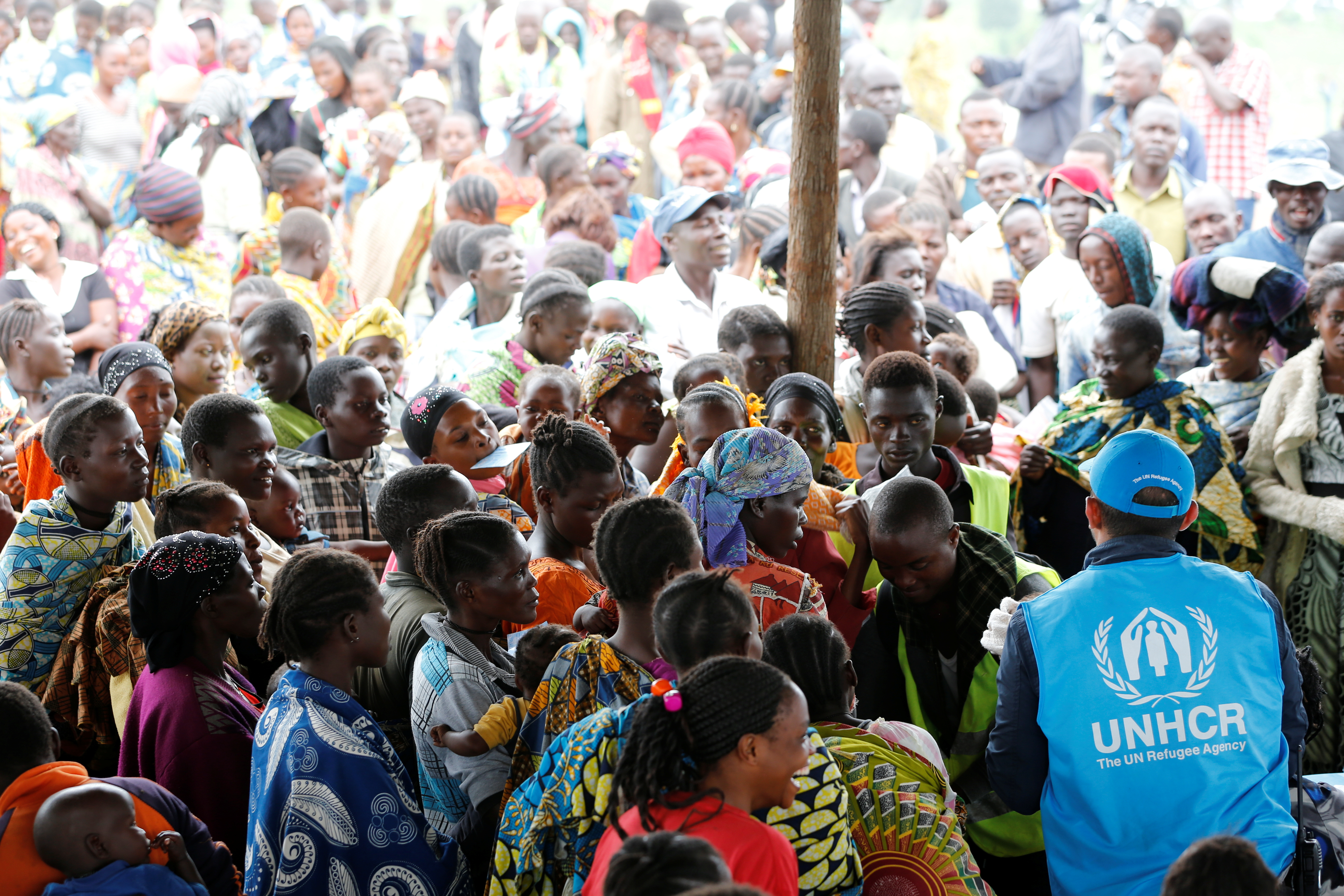 A UN worker monitors Congolese refugees who fled from the Democratic Republic of Congo by boat across Lake Albert, upon arrival at United Nations High Commission for Refugees (UNHCR) in settlement camp in Kyangwali