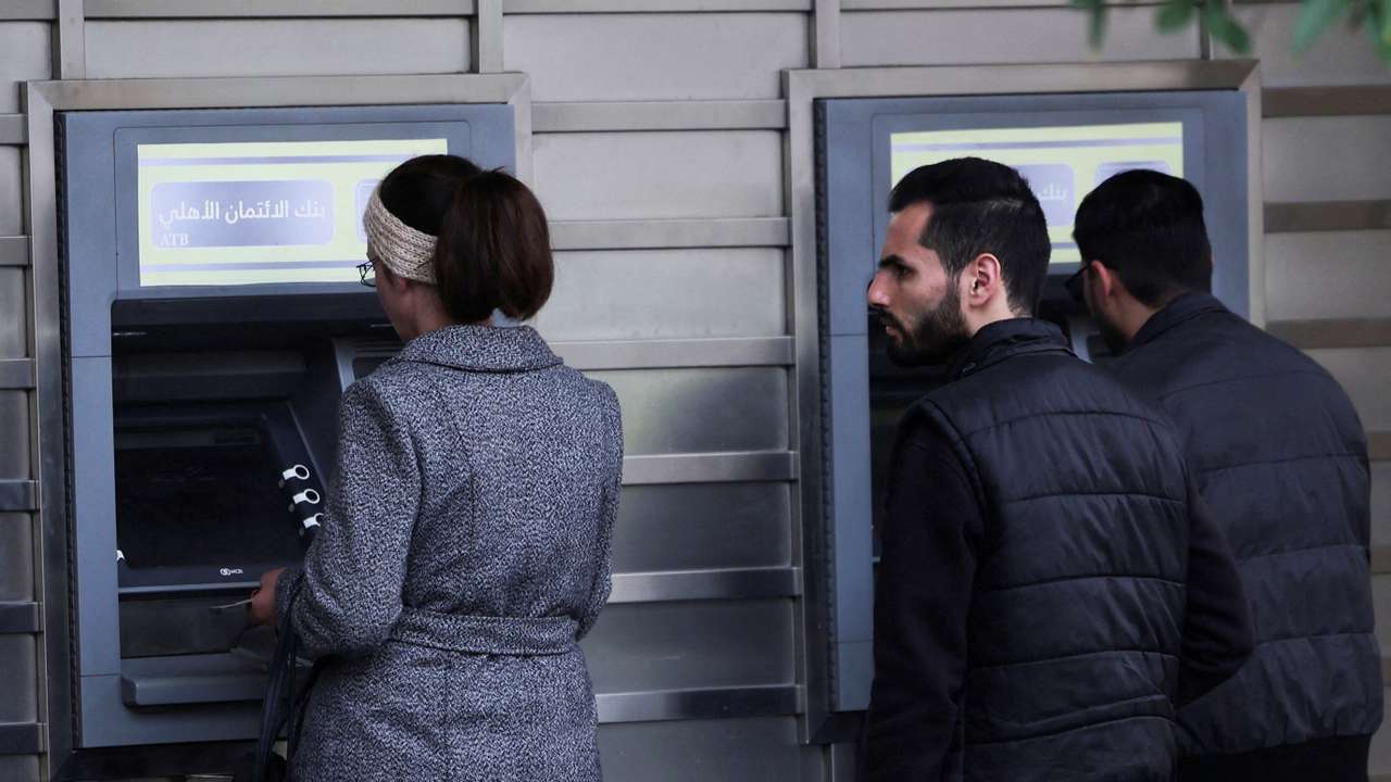 FILE PHOTO: People wait in front of ATM machine, after rebels seized the capital and ousted Syria's Bashar al-Assad, in Damascus