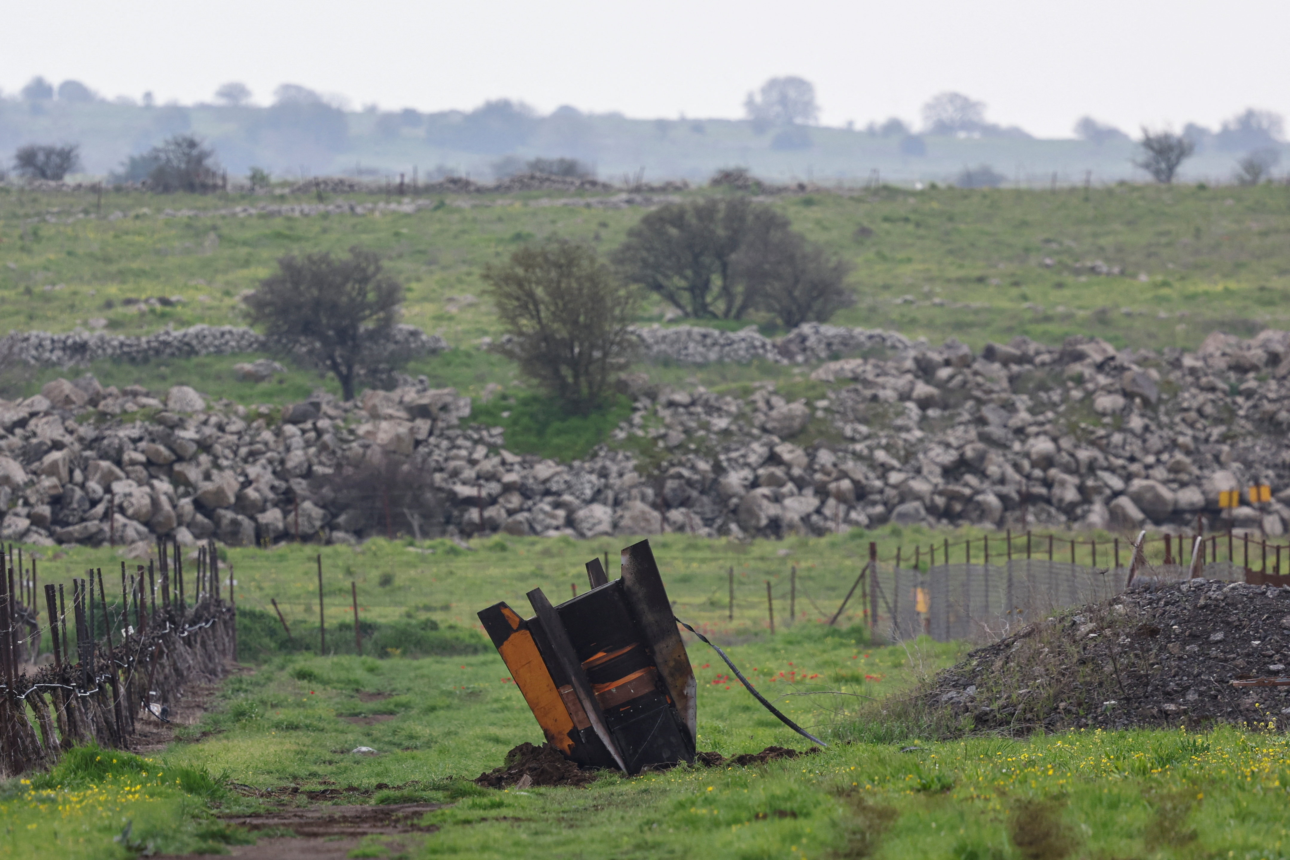 The tail fin of a large missile protrudes from a field, following barrages of missiles from Iran towards Israel, amid the U.S.-Israel conflict with Iran, in the Israeli-occupied Golan Heights