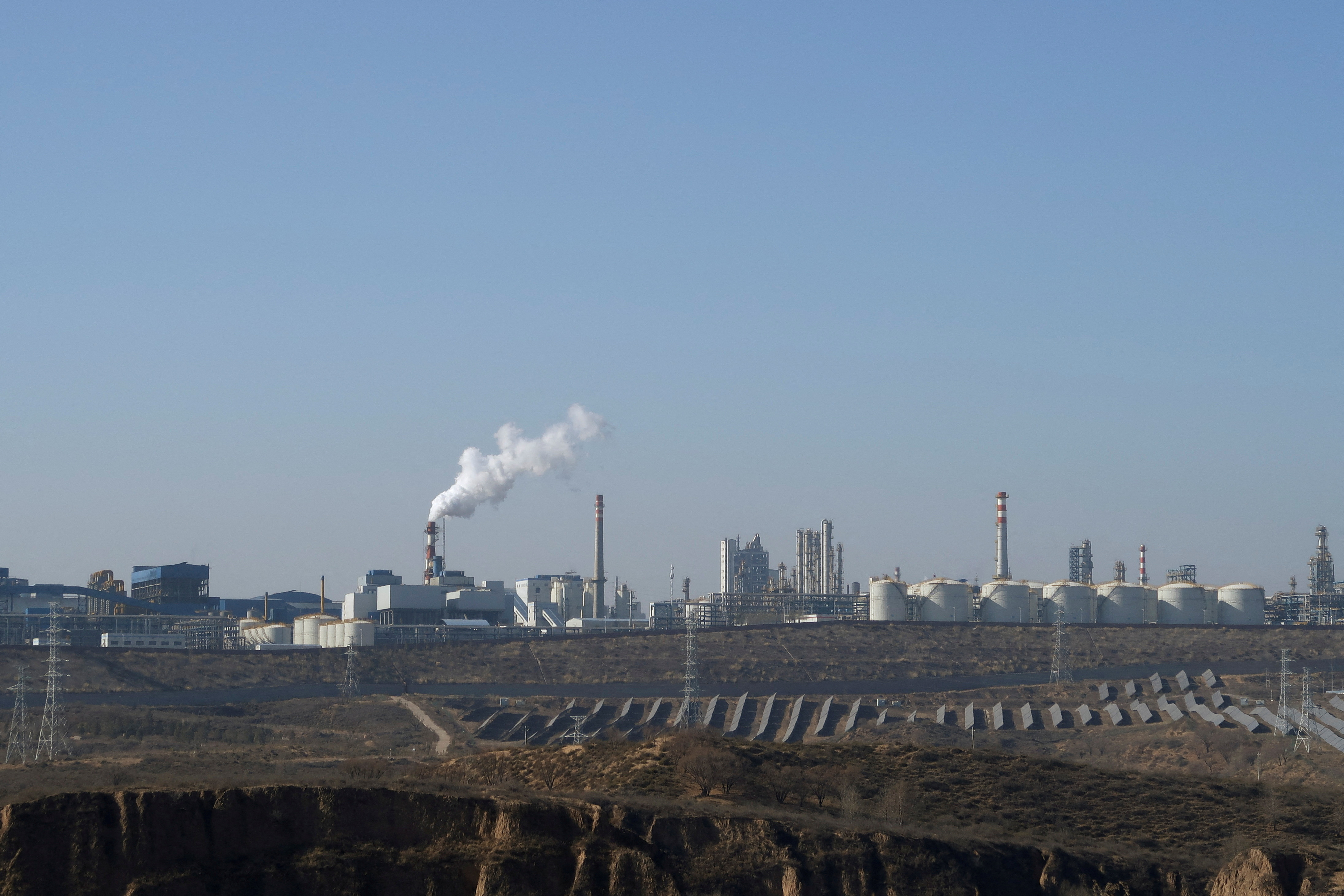 FILE PHOTO: Solar panels lie in front of factories at Jinjie Industrial Park in Shenmu