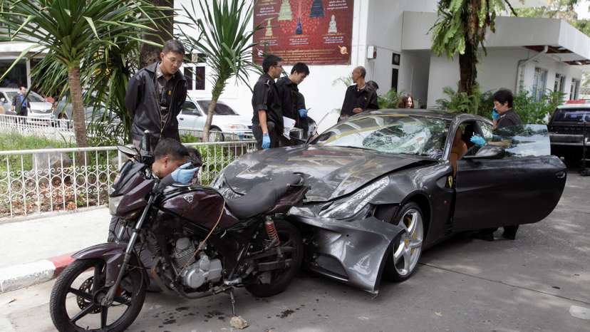 FILE PHOTO: Policemen examine damaged Ferrari at home of late Red Bull founder Yoovidhaya in Bangkok