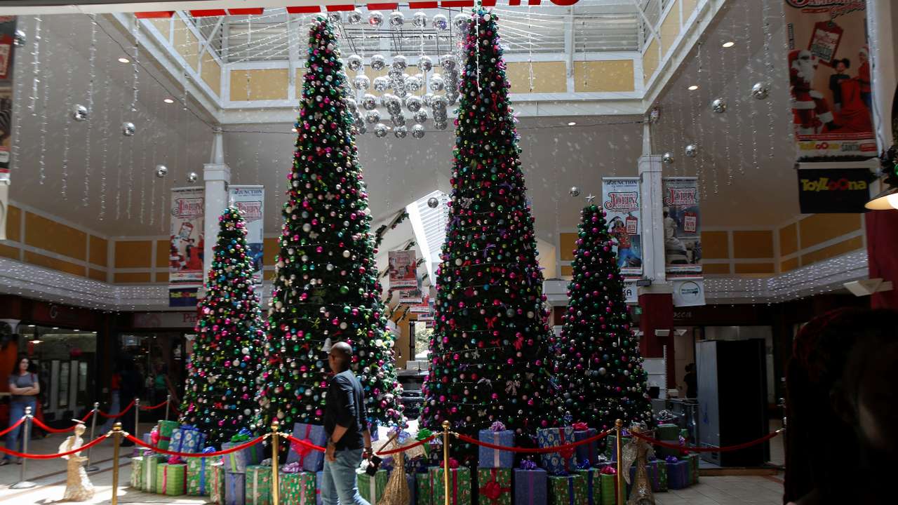 A shopper walks past Christmas tree decorations at the Junction Shopping Mall ahead of Christmas, in Nairobi