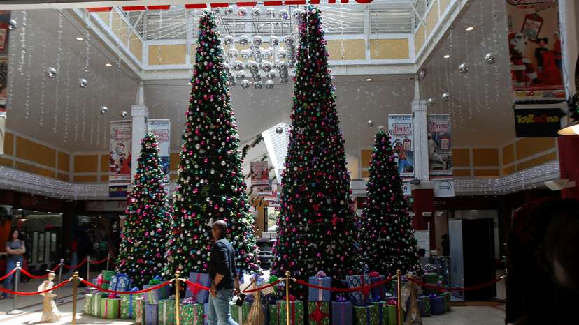 A shopper walks past Christmas tree decorations at the Junction Shopping Mall ahead of Christmas, in Nairobi