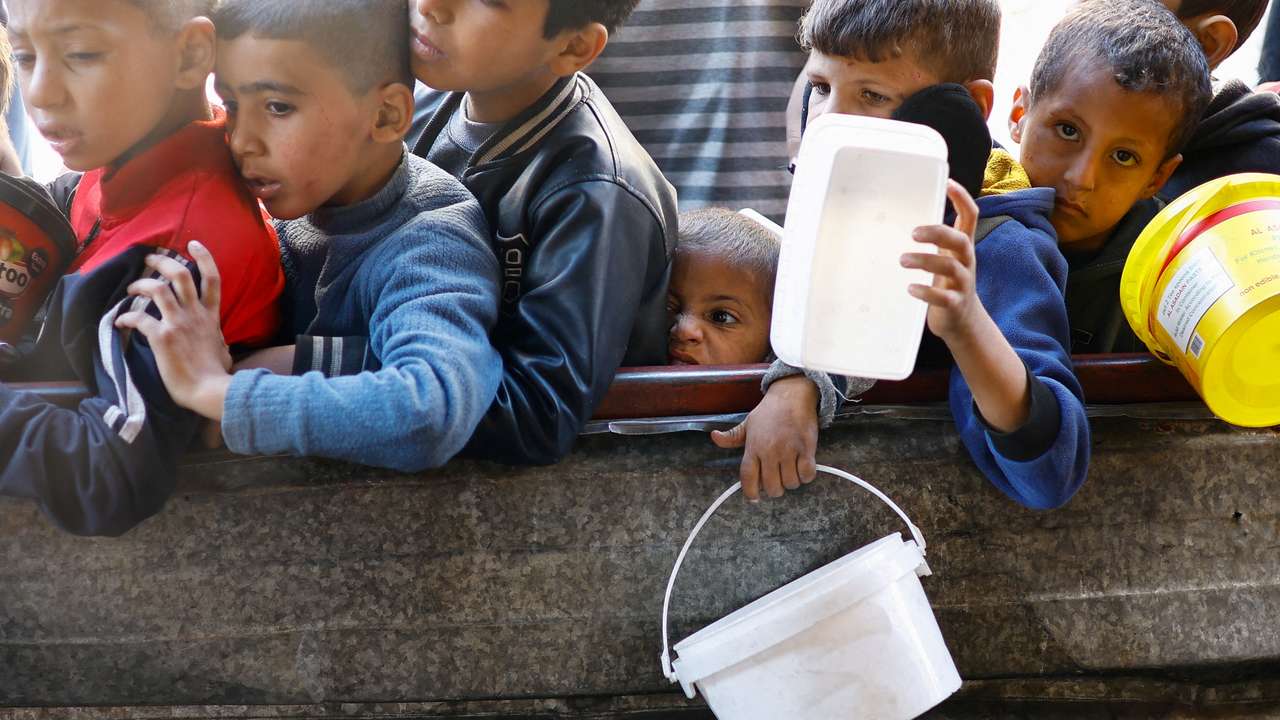 Palestinians wait to receive food amid shortages of food supplies, in Rafah in the southern Gaza Strip