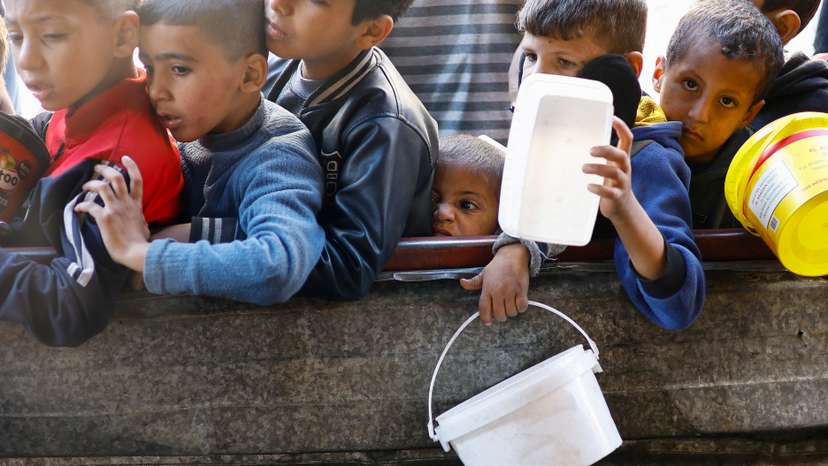 Palestinians wait to receive food amid shortages of food supplies, in Rafah in the southern Gaza Strip