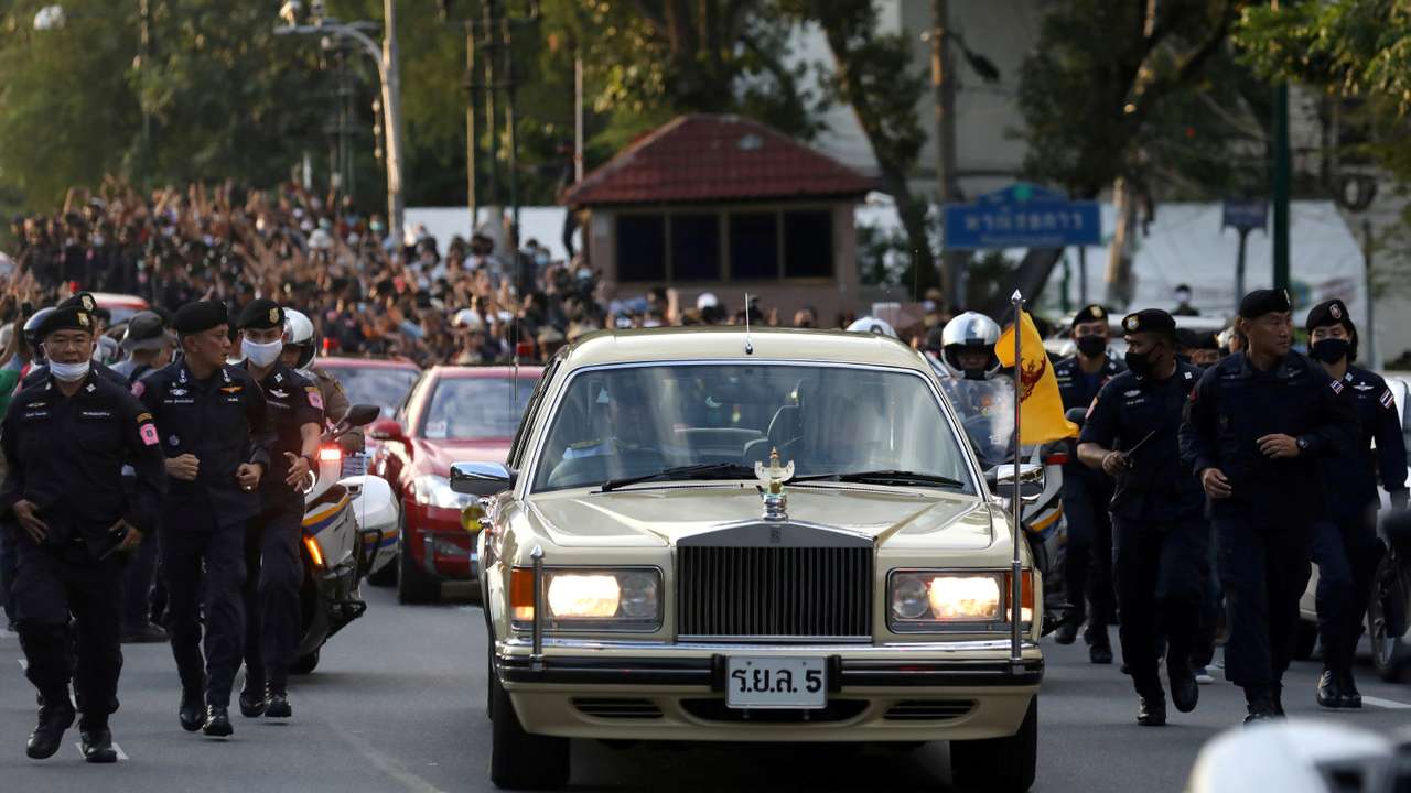 FILE PHOTO: The royal motorcade carrying Thailand's Queen Suthida and Prince Dipangkorn drives past a group of anti-government demonstrators in front of Government House in Bangkok